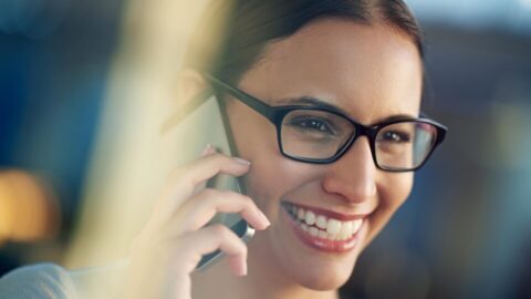 Business woman, smile and mobile conversation in office for communication, sales and corporate deals. Person, happy and talking on cellphone device for agreement, negotiation and job opportunity.