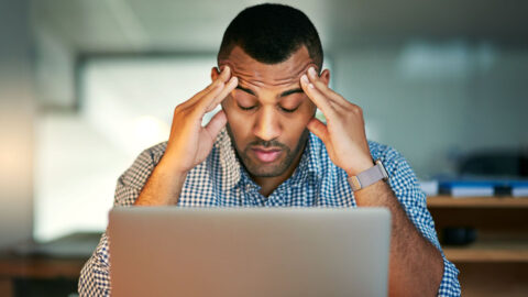 Stressed out. Cropped shot of a young businessman looking stressed while working in the office.