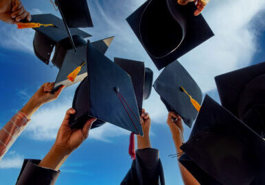 Graduates throwing graduation hats Up in the sky